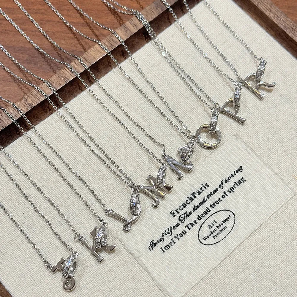 Women's 26-letter initial necklace in titanium steel with a round zircon pendant on a cross chain, colour option shown