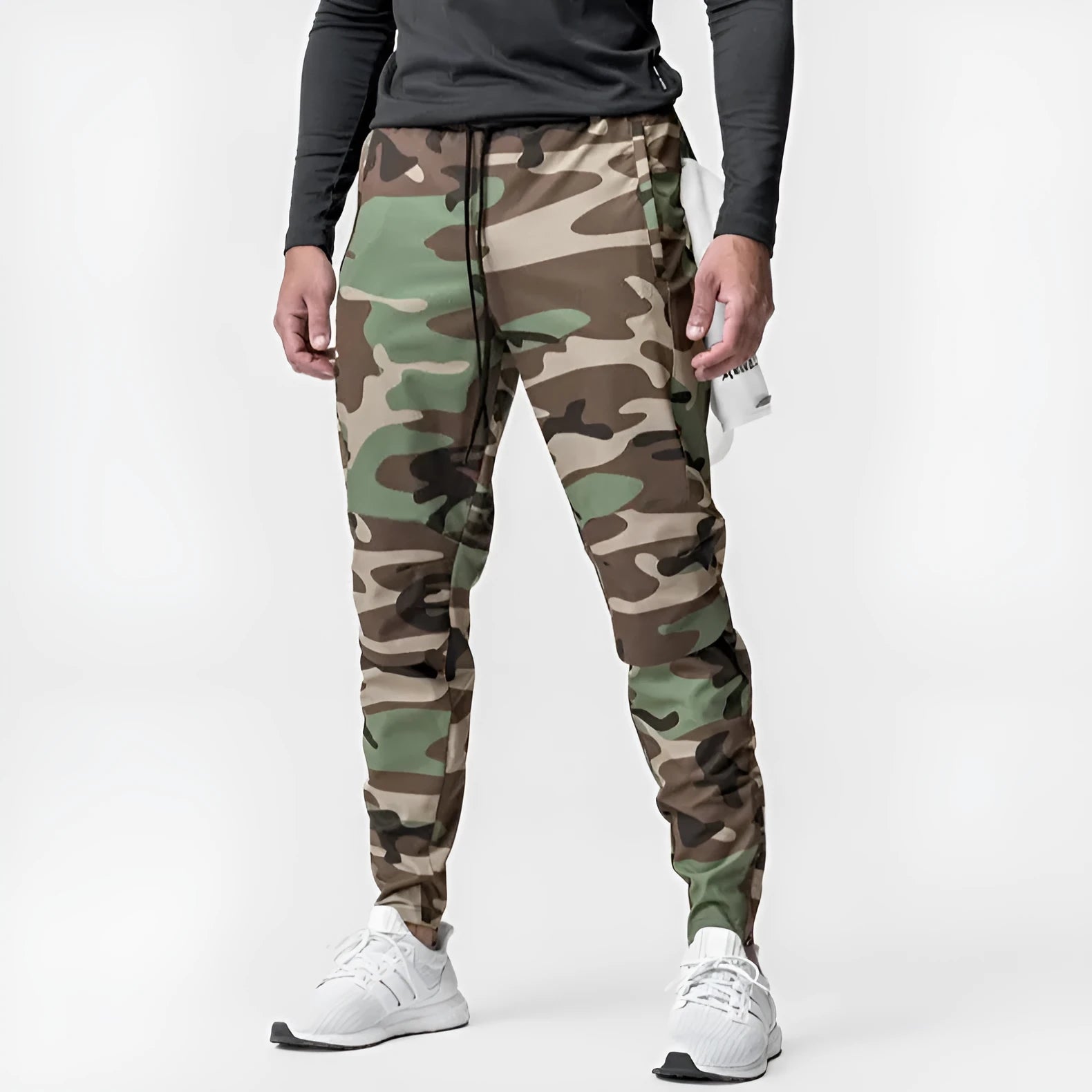 Man wearing dark grey loose-fit ankle-tied fitness trousers made of quick-drying polyester.