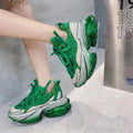 Women's green leather sports shoes with thick jelly soles and cross tie laces on a white background.