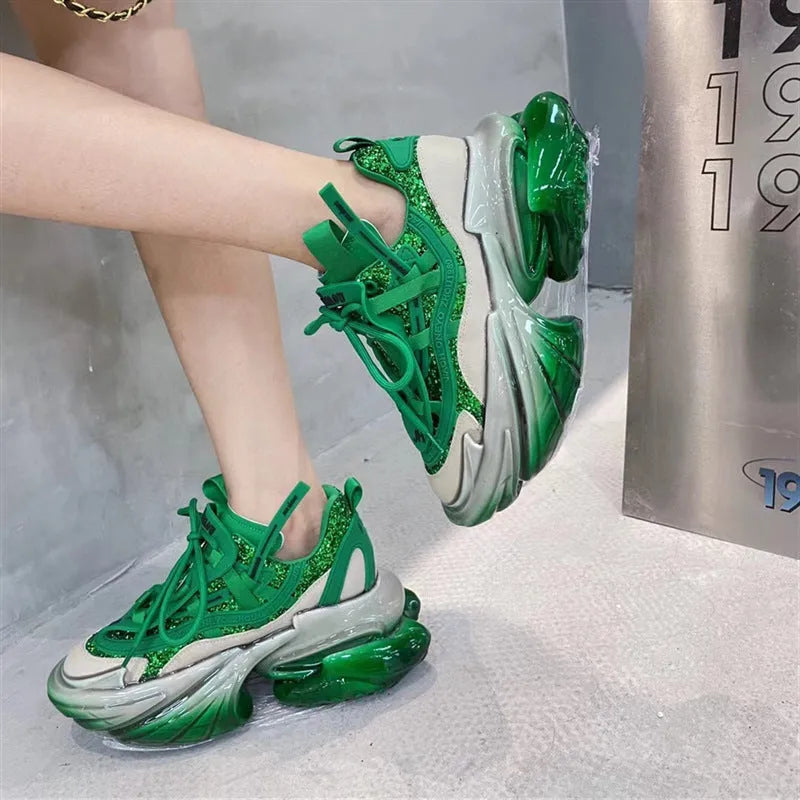Women's green leather sports shoes with thick jelly soles and cross tie laces on a white background.
