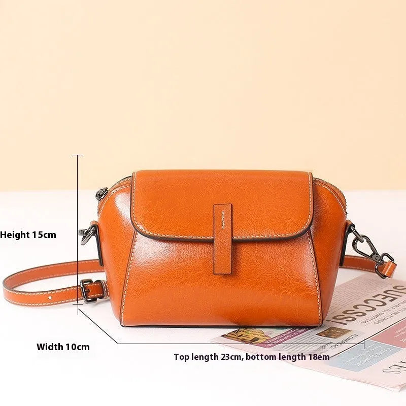 Brown genuine oil wax leather women's messenger bag with crossbody strap and sewing line detail.