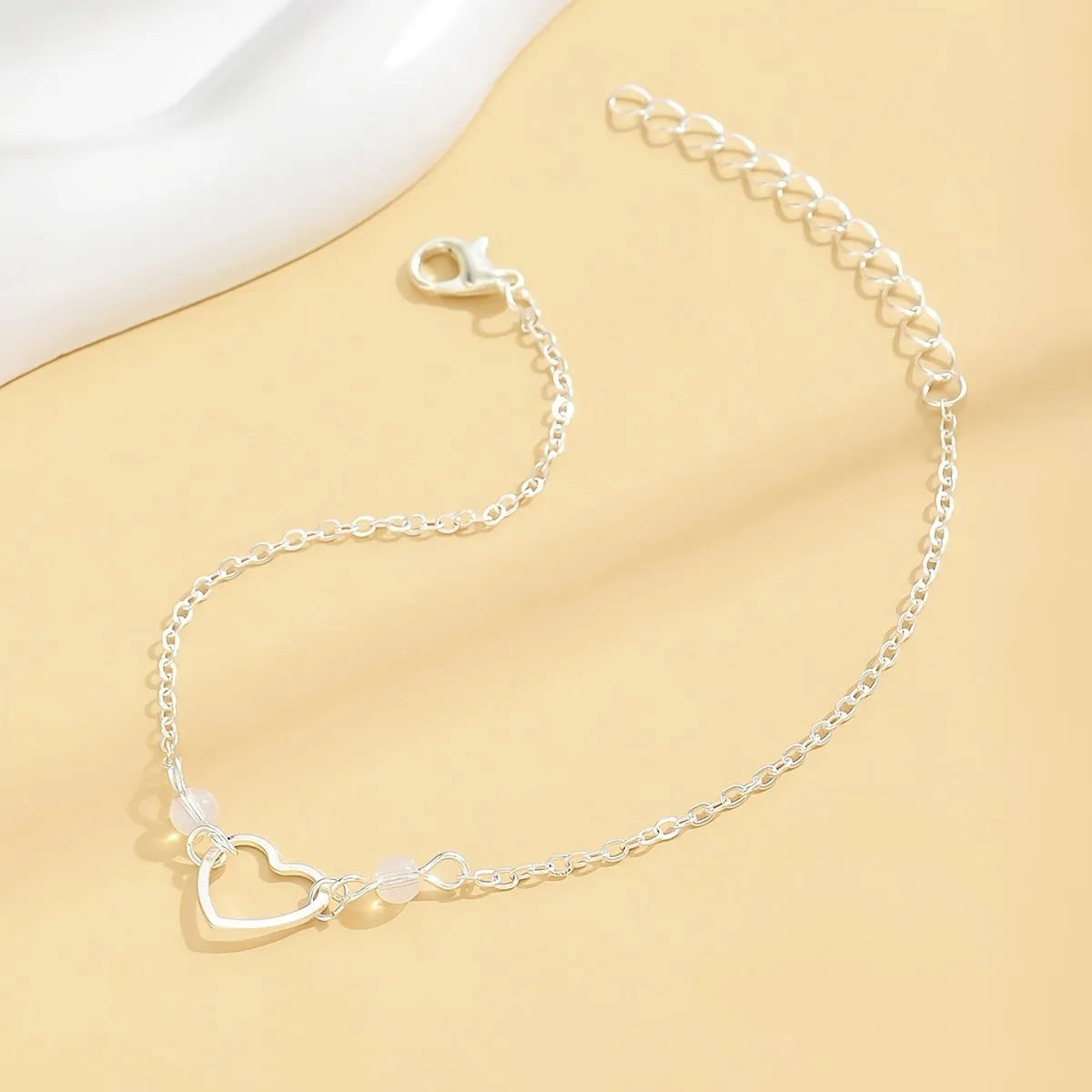 Adjustable women's anklet with heart-shaped pendant in gold and silver alloy finishes