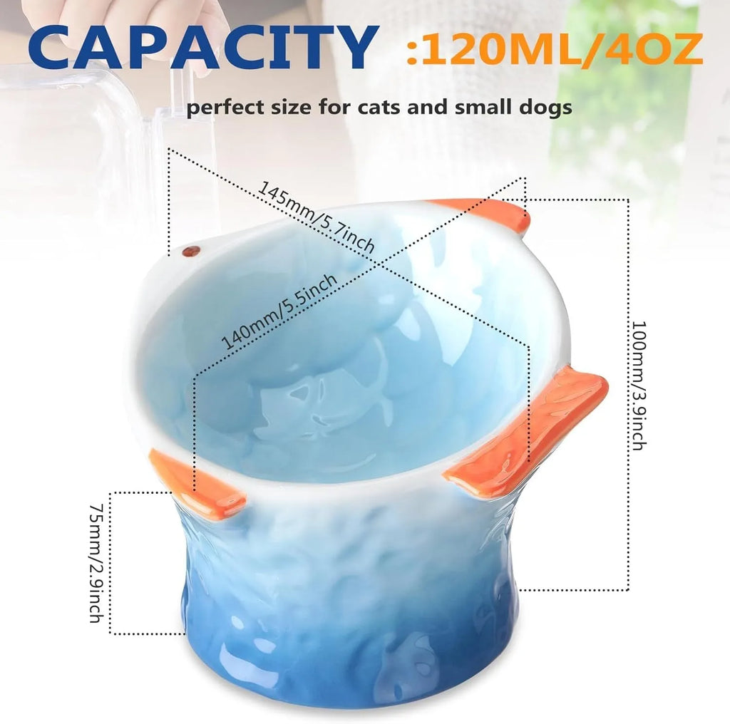 Set of four blue, fish-shaped ceramic cat bowls with a tilted design on a kitchen counter.