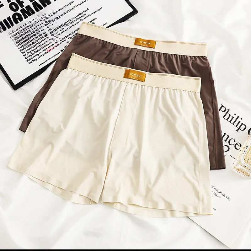Pack of three men's loose fit ice silk boxer shorts in solid colours on a mid-waist model.