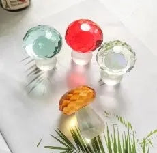 Colourful geometric mushroom crystal decorative ornament in transparent, green, red, or yellow.