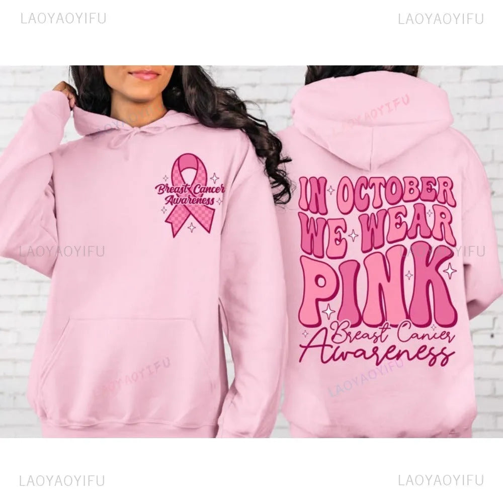 Pink breast cancer awareness hoodie with retro pattern and side pocket on a hanger.