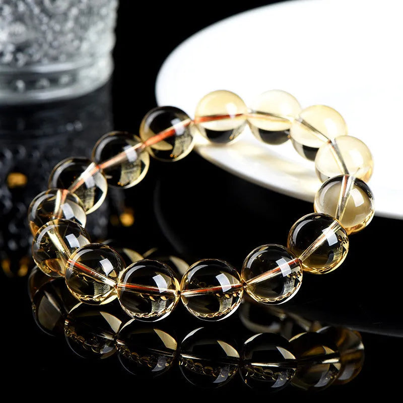 Handmade natural citrine scattered beads ball bracelet on a wrist, showing polished yellow gemstones.