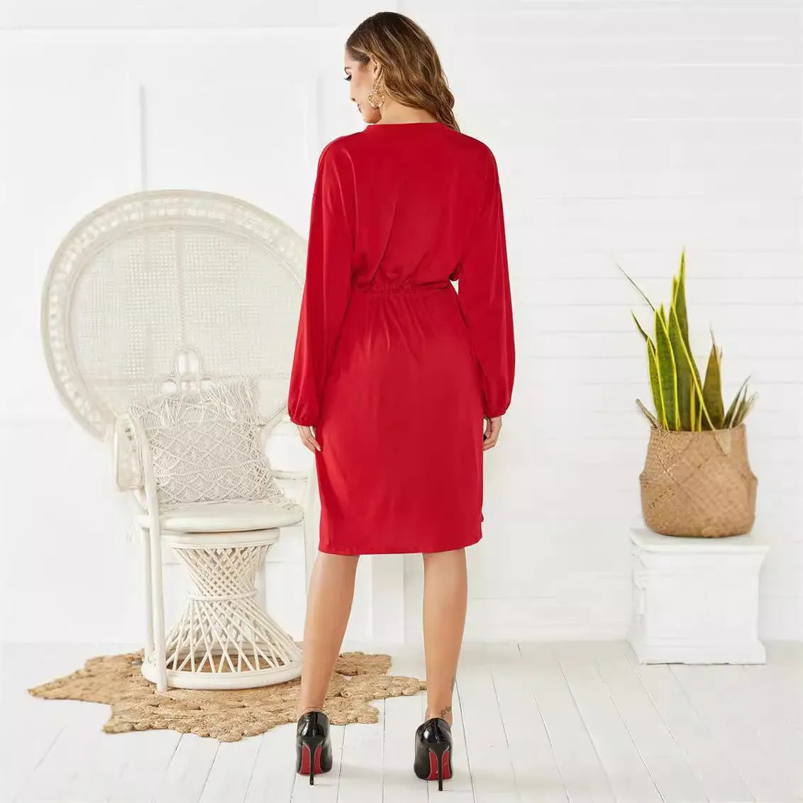 Women's black A-line midi dress with long sleeves, elastic cuffs, and a cinched elastic waist belt.