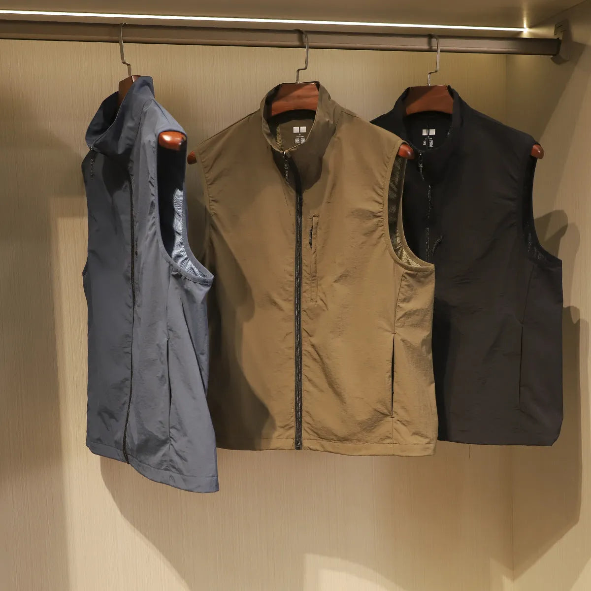Men's solid colour nylon vest with side pockets in a straight, cardigan-style cut.