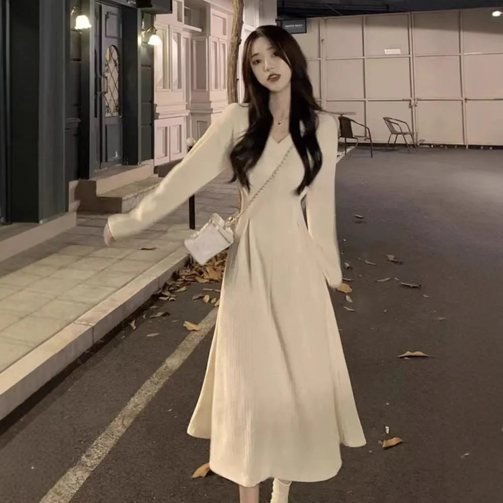 Women's white V-neck knitted dress with long princess sleeves and suspender skirt silhouette