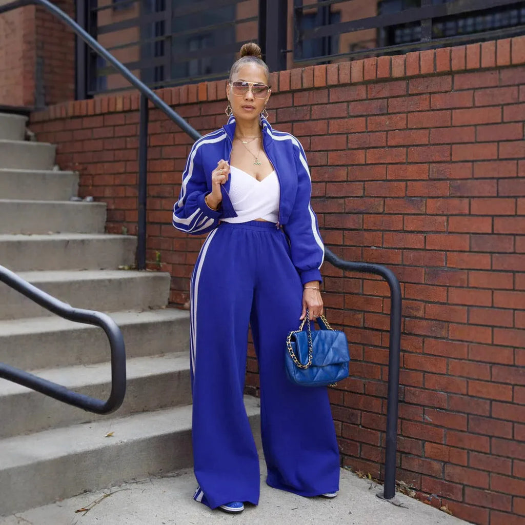 A striped grey two-piece tracksuit set with a zipper top and trousers on a mannequin.