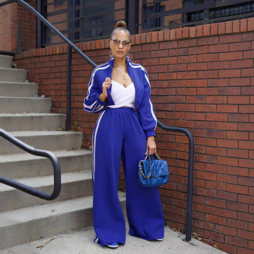 A striped grey two-piece tracksuit set with a zipper top and trousers on a mannequin.
