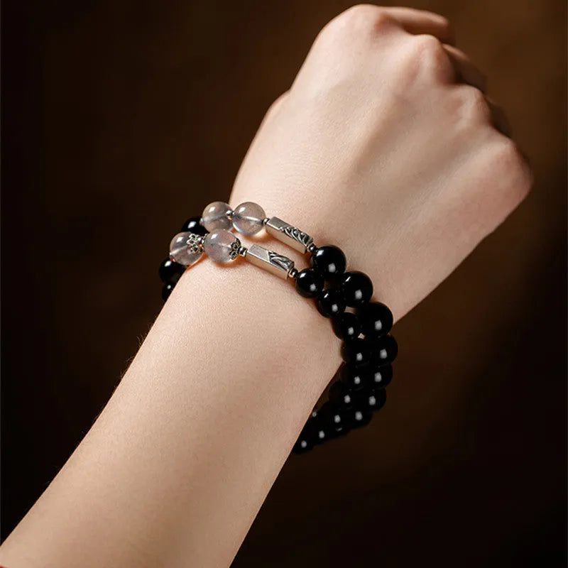 Black obsidian Buddha bead couple bracelets showing 8mm and 10mm sizes on a background.