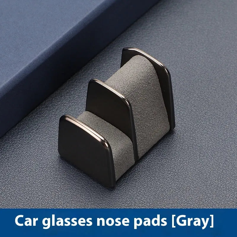 Zinc alloy and leather glasses clip for car dashboard in black, grey, green, or red.