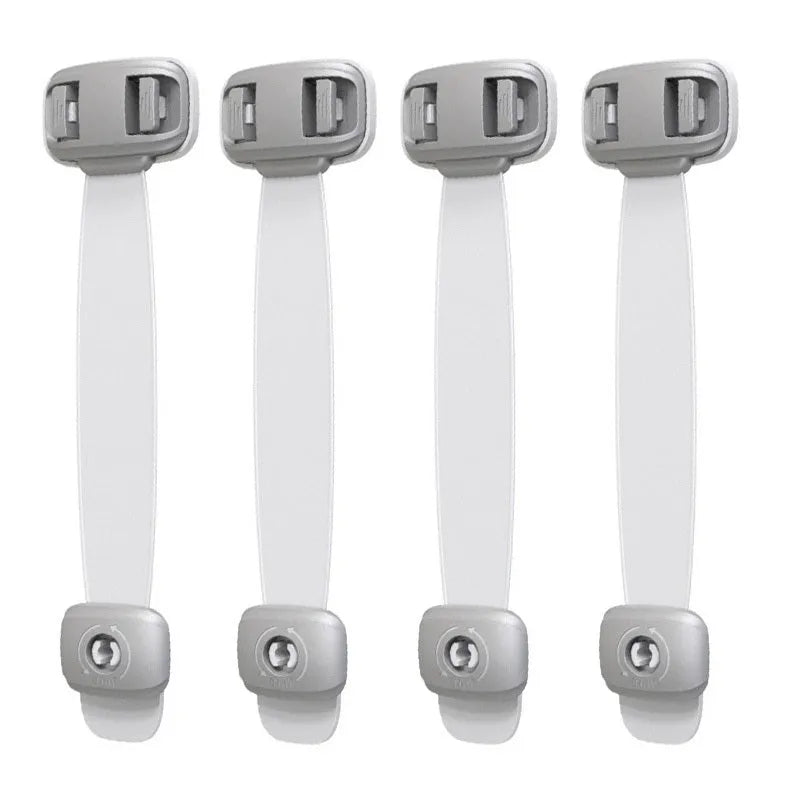 Grey and green adjustable child safety cabinet locks with adhesive backing on a kitchen drawer.