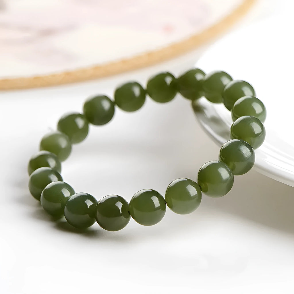 Unisex Hetian Jade ball bracelet with polished beads in clear colours on a wrist.