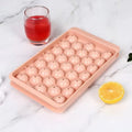 Blue silicone ice cube tray with lid showing 33 round holes for large ice cubes