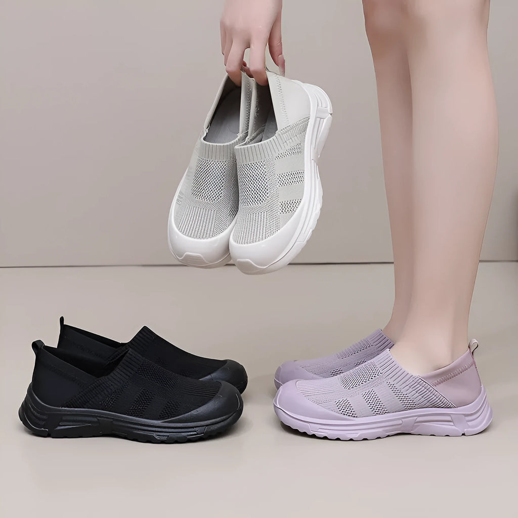 Women's black slip-on casual shoes with round toe and flat PVC sole.