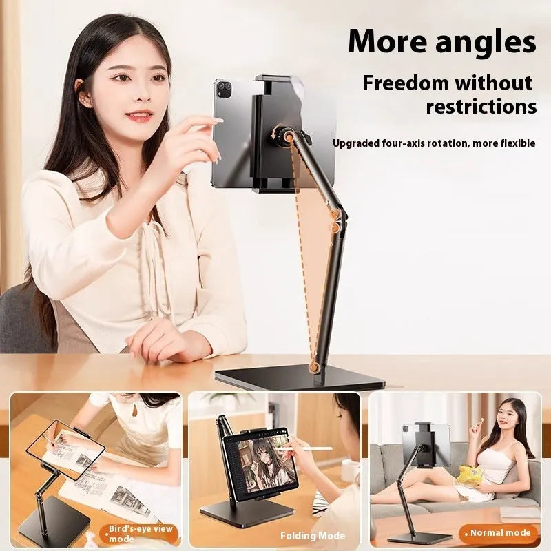 Silver alloy desktop phone bracket with double arms holding a smartphone, shown with a remote control on a wooden desk.