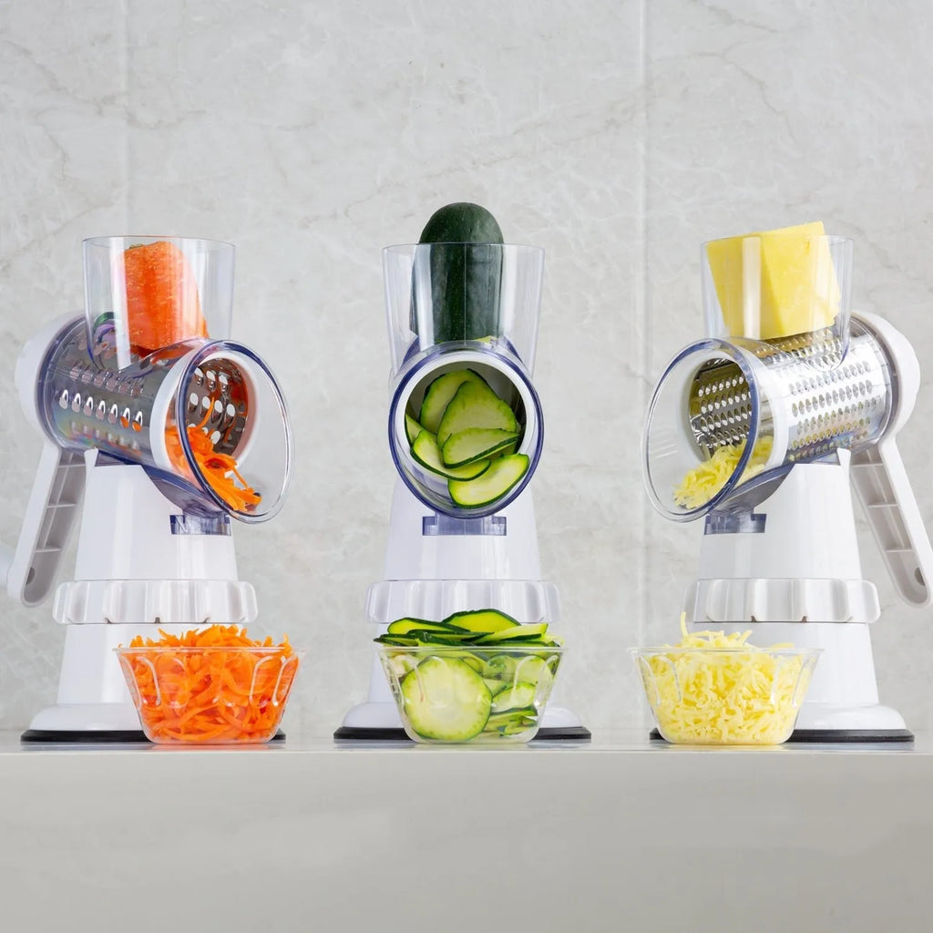White manual vegetable slicer, grater, and chopper with three stainless steel blades and suction feet.