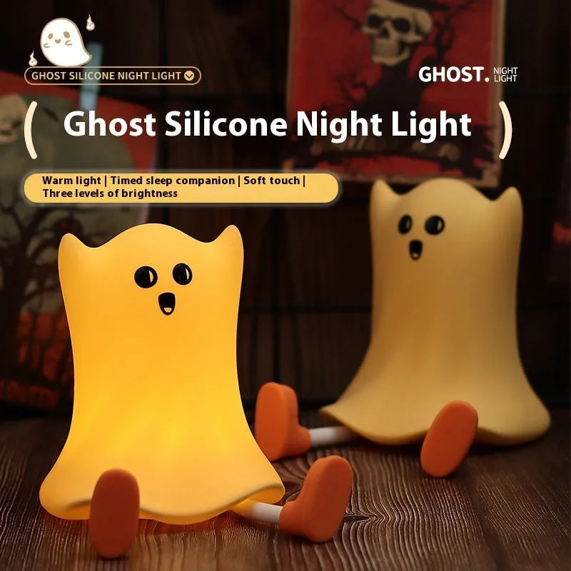 Cartoon ghost-shaped silicone bedside lamp with touch control, soft yellow glow on a bedside table