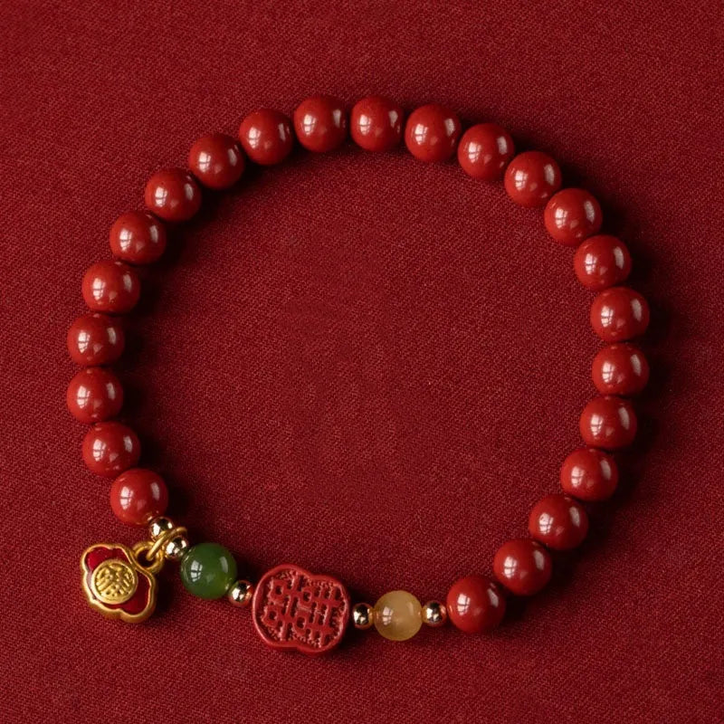 Emperor Sandstone Happy Eyebrow Bracelet with cinnabar accents and fu character charm on wrist.