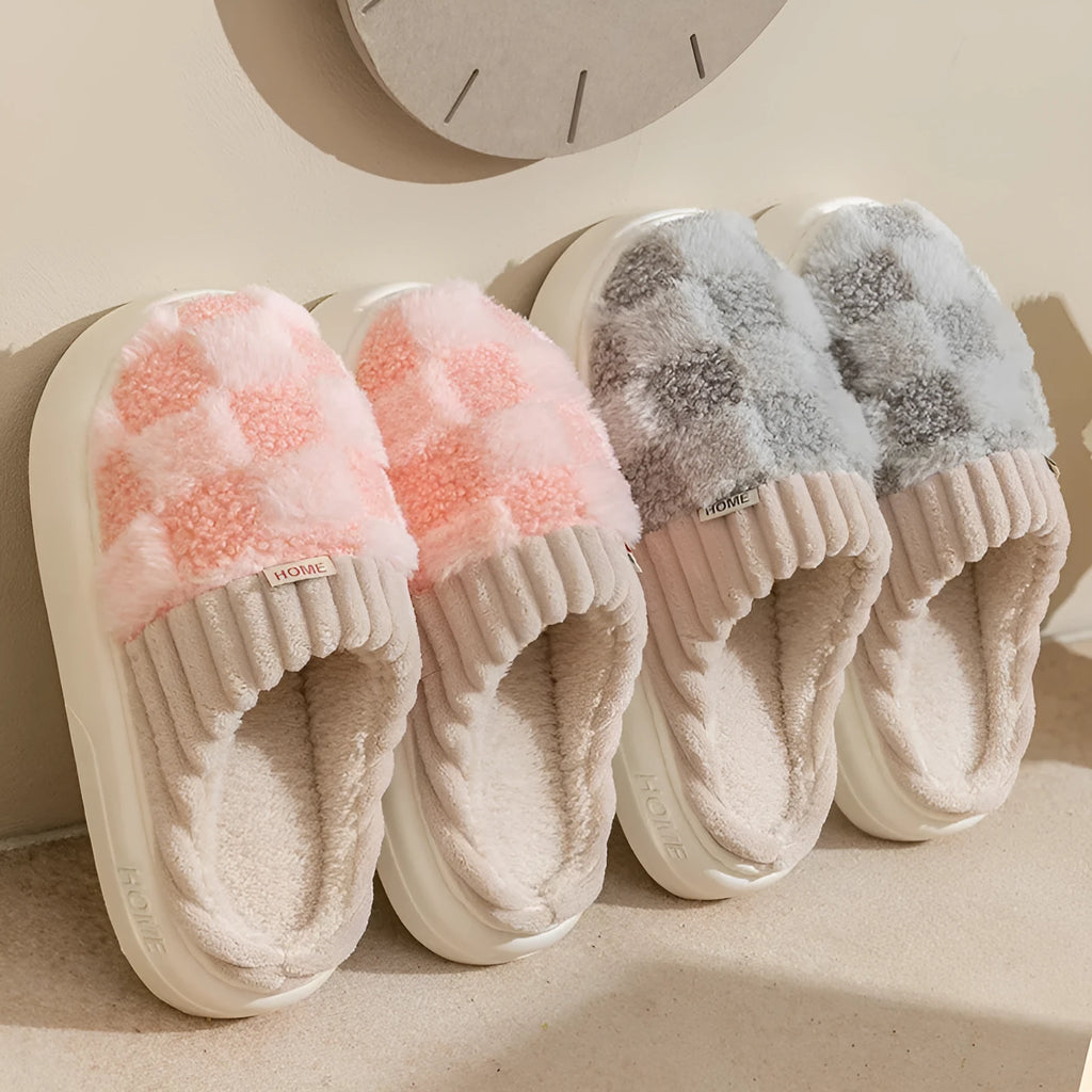 Plaid pattern women's plush slippers with round toe and flat heel on a coloured background.