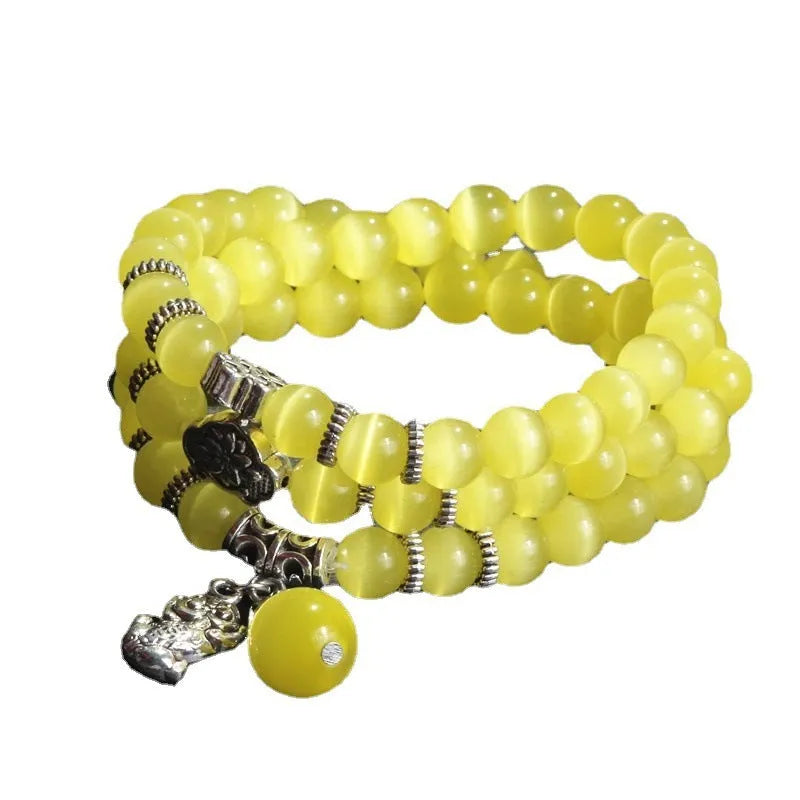 Women's opal bracelet with a Cat Eye charm, shown in one of six colours, wound three times around a wrist.