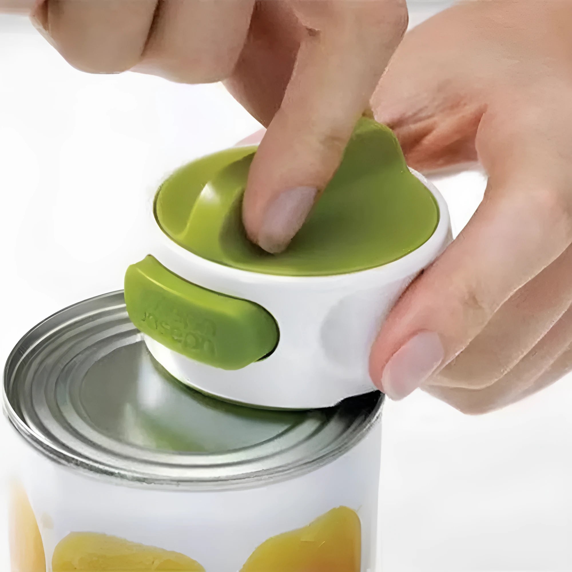 Green stainless steel bottle opener gadget for screw-top lids on a kitchen counter.