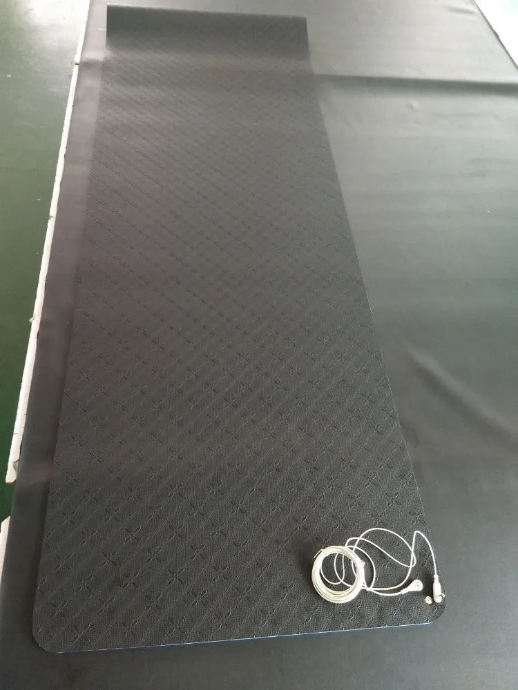 Blue yoga mat with plant patterns, showing grounding wire and non-slip texture.