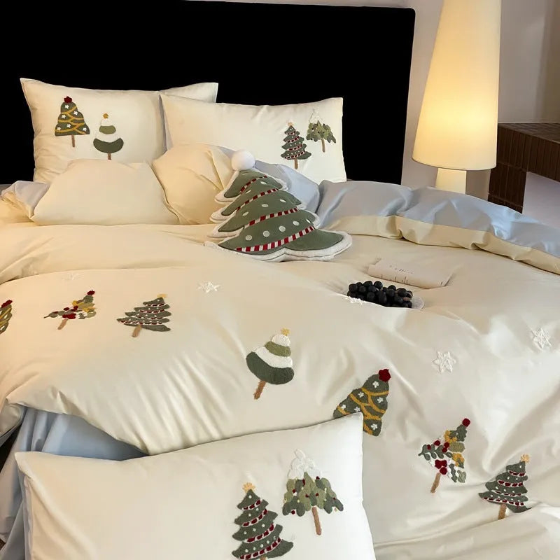 Pure cotton Christmas tree towel embroidery bedding four-piece set in cream blue on a bed.