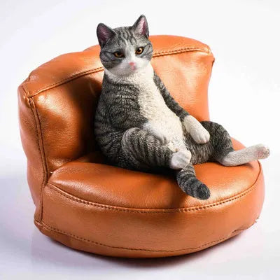 Resin lazy cat car ornament with fabric sofa, approximately 7.5cm high.