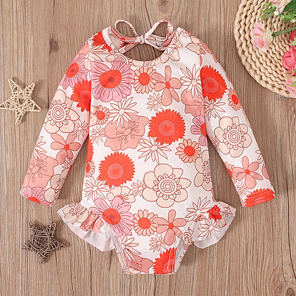Girl's floral print swimsuit with crew neck and open back in orange red colour.