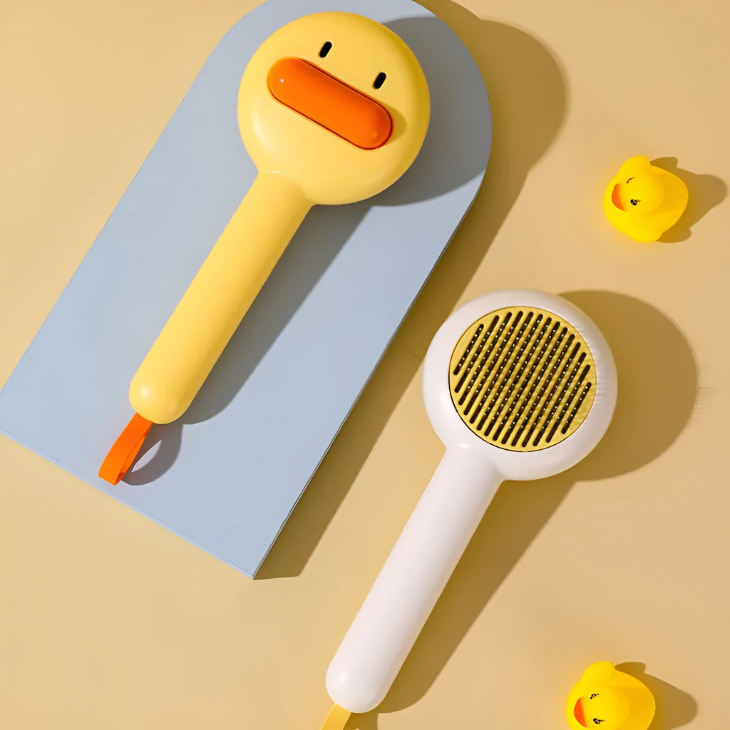 Small yellow duck-shaped pet grooming comb with needle pins for cats and dogs