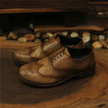 Men's light brown distressed leather lace-up shoes with hand-carved vintage detailing