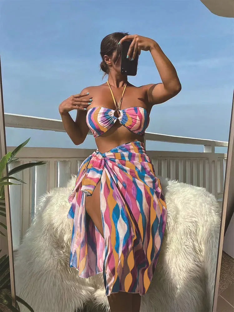 Women's yellow green printed three-piece bikini set with matching beach skirt laid flat.