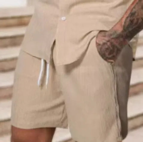 A man wearing a striped short-sleeve shirt and matching shorts from a casual suit set.