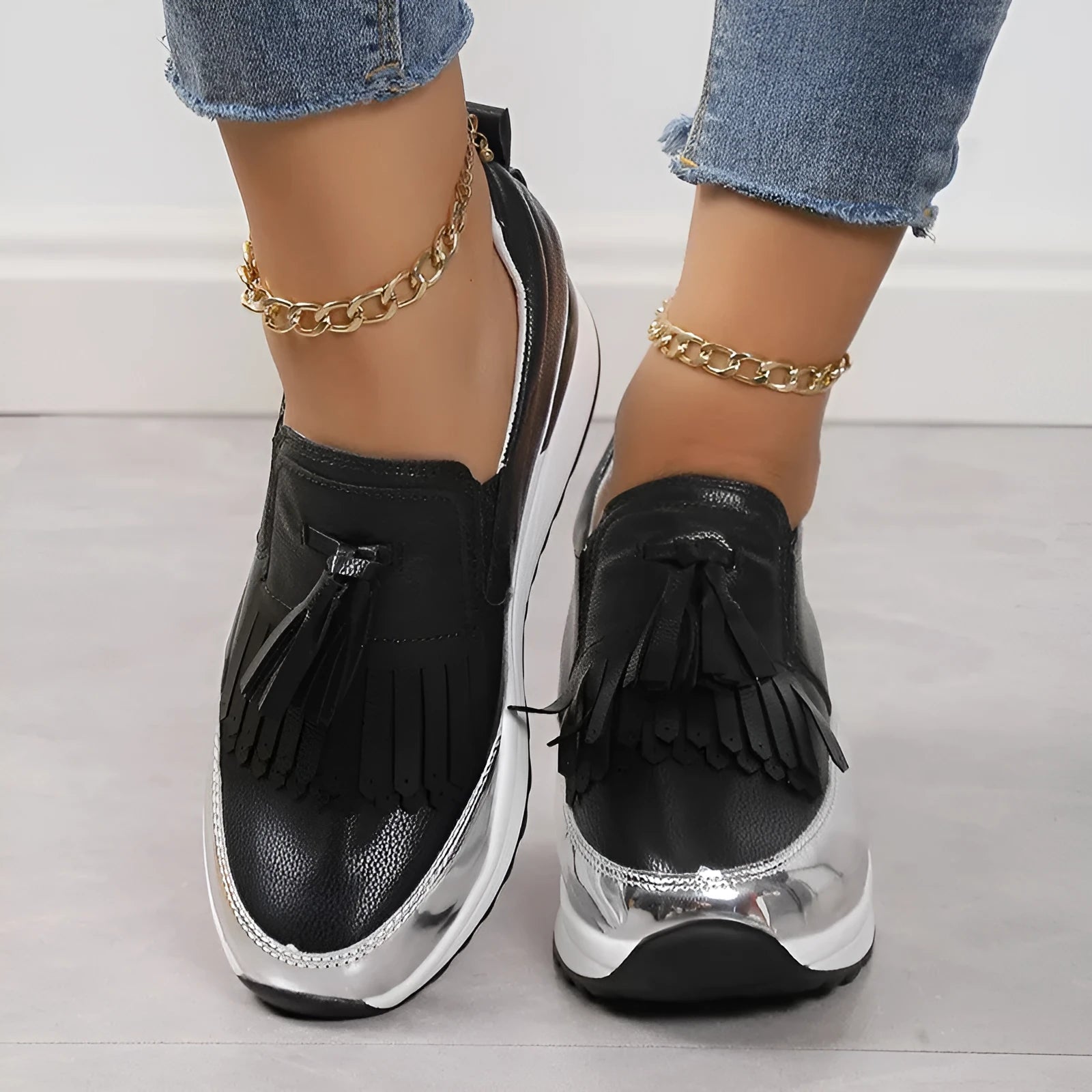 Women's black casual shoes with tassel detail and muffin wedge heel on white background