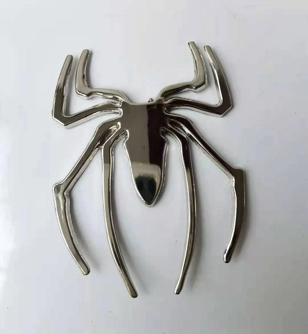 Three-dimensional metal spider bumper sticker in zinc alloy, showing gold, silver, black, and red colour options.