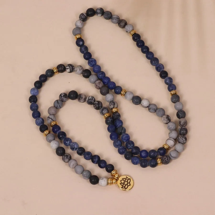 Blue patterned stone bead multi layer alloy bracelet with clasp on a white background.