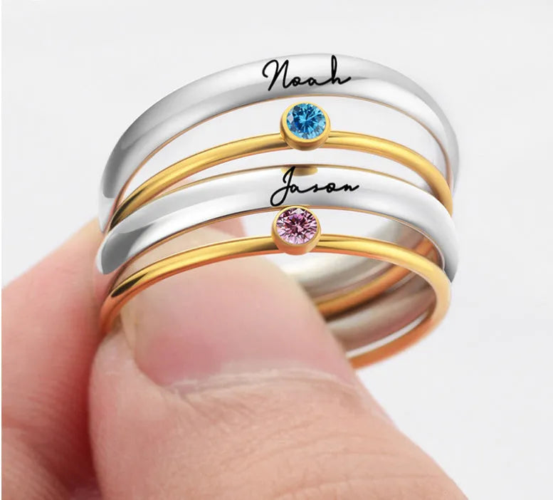 Geometric titanium steel ring with engraved December birthstones in a superimposed design on a hand.