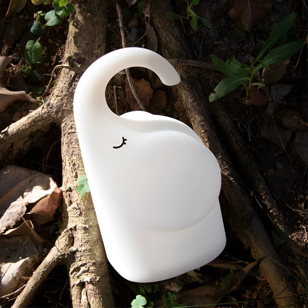 DOMI elephant-shaped silicone night light in warm white, showing its compact size.