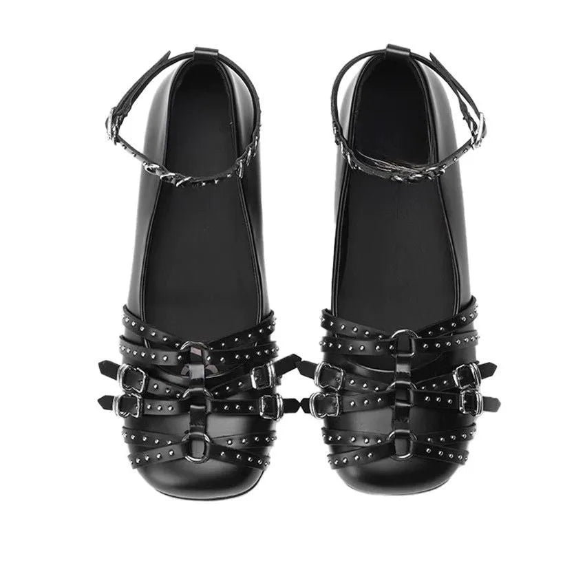 Women's black patent leather retro pumps with a buckle and low flat heel on a white background.