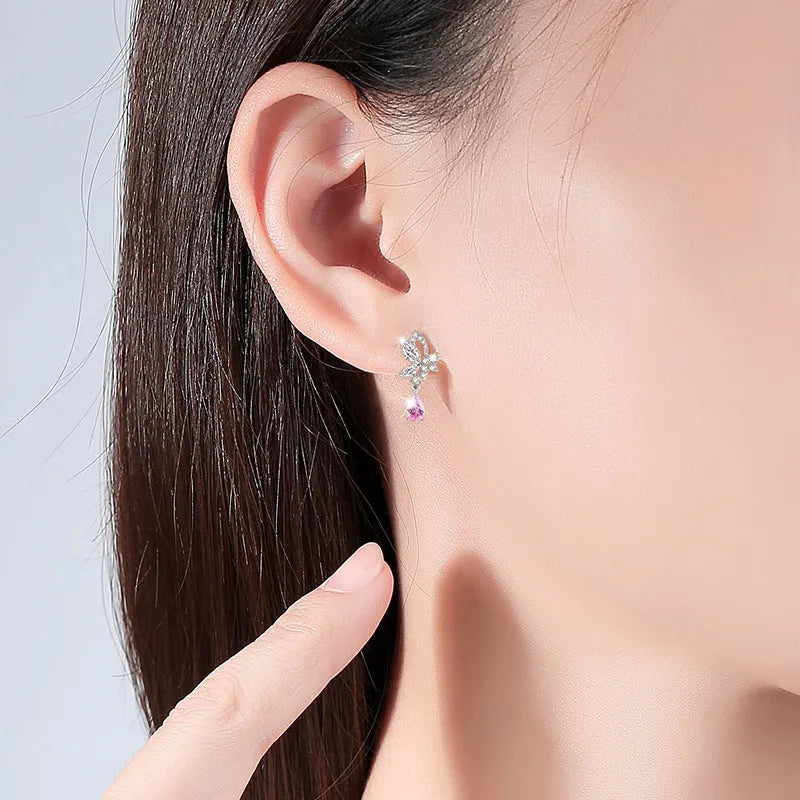 A pair of silver butterfly stud earrings with clear crystals on a white background.