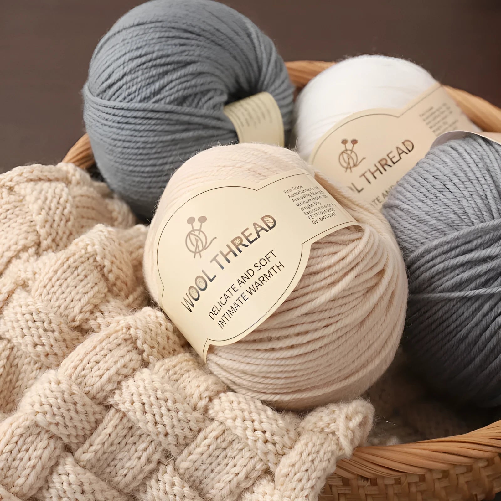 Roll of hand knitting wool yarn for baby clothes in assorted colours including green, beige, and red.