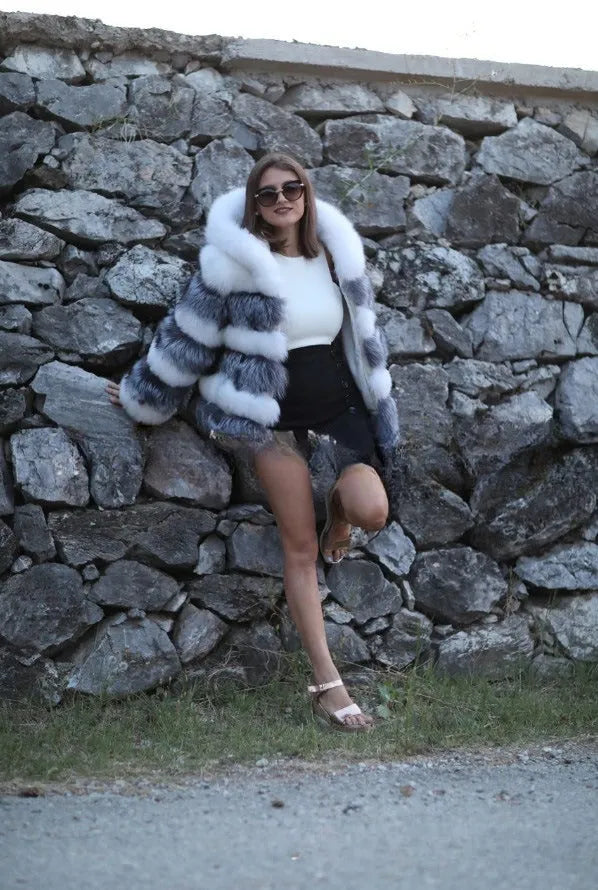 Loose-fitting women's faux fur coat with a hood in brown, shown in streetwear style.