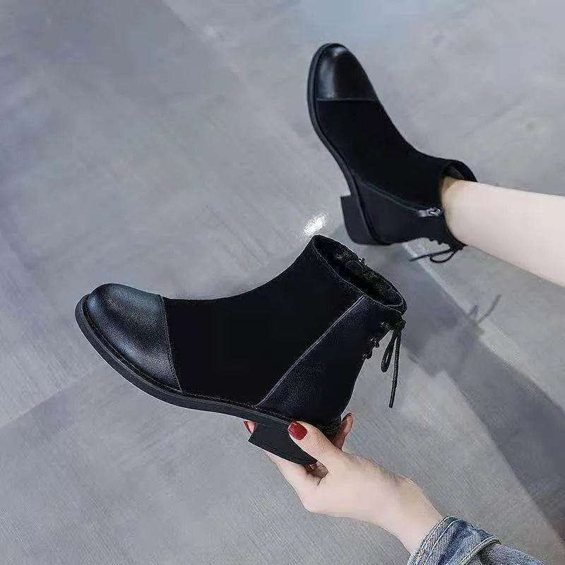 Black women's knee-high Martin boots with side zip, round toe, and block heel on a rubber sole.