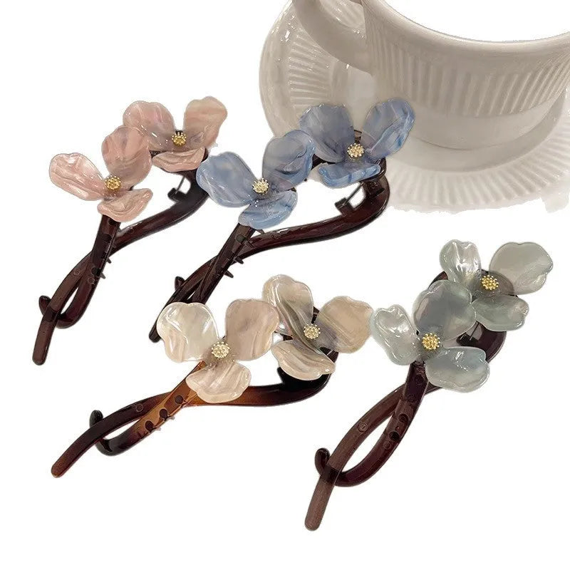 Retro flower petal bobby pin hair accessory in acrylic, shown on a background.