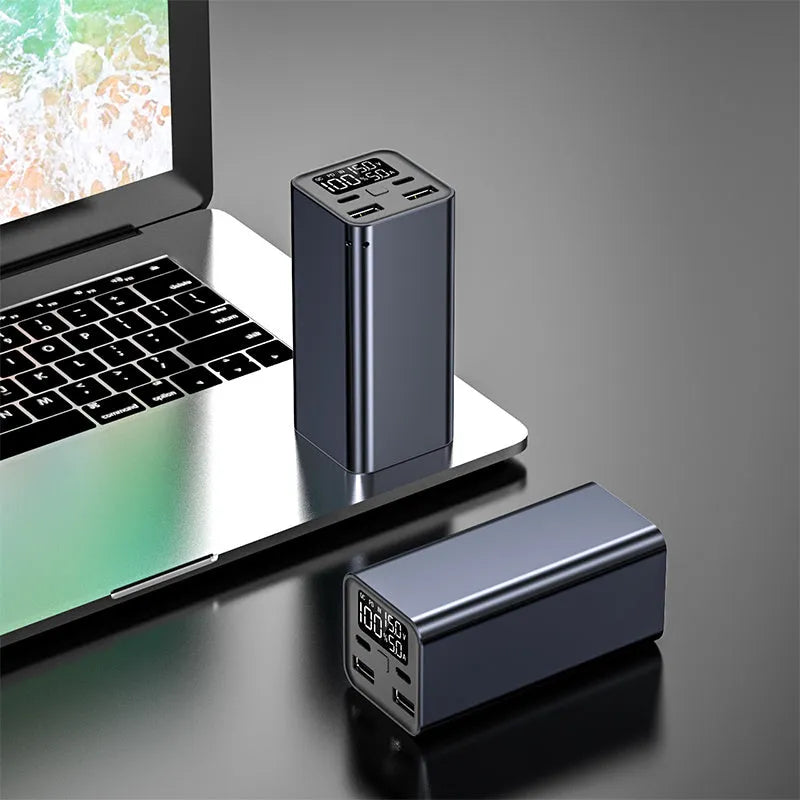 A black metal 65W laptop power bank with 20000mAh capacity, showing size compared to a hand.