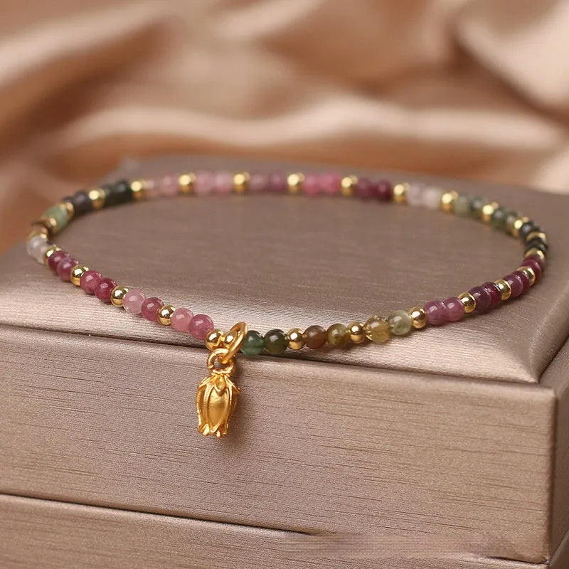 Natural tourmaline beaded floral anklet shown as adjustable bracelet on woman's wrist